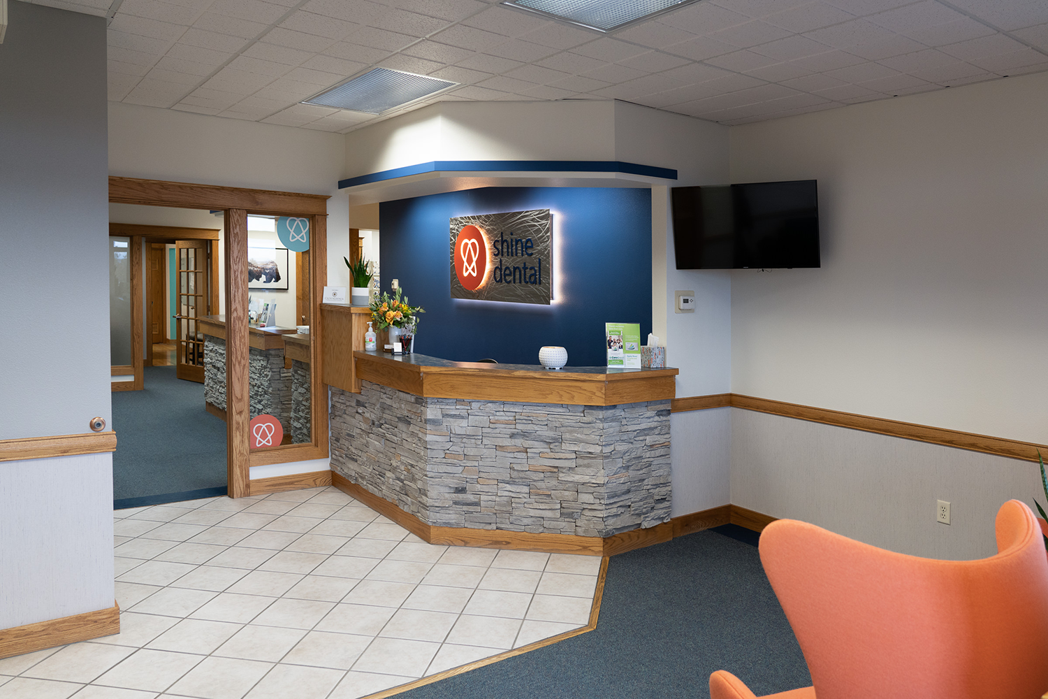 A waiting room with a reception desk and a chair.