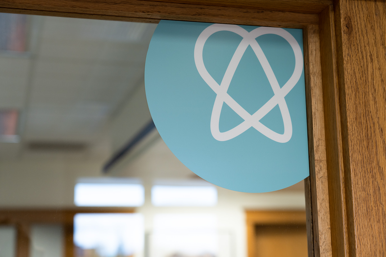 A blue sign with a heart on it is on a wooden door.