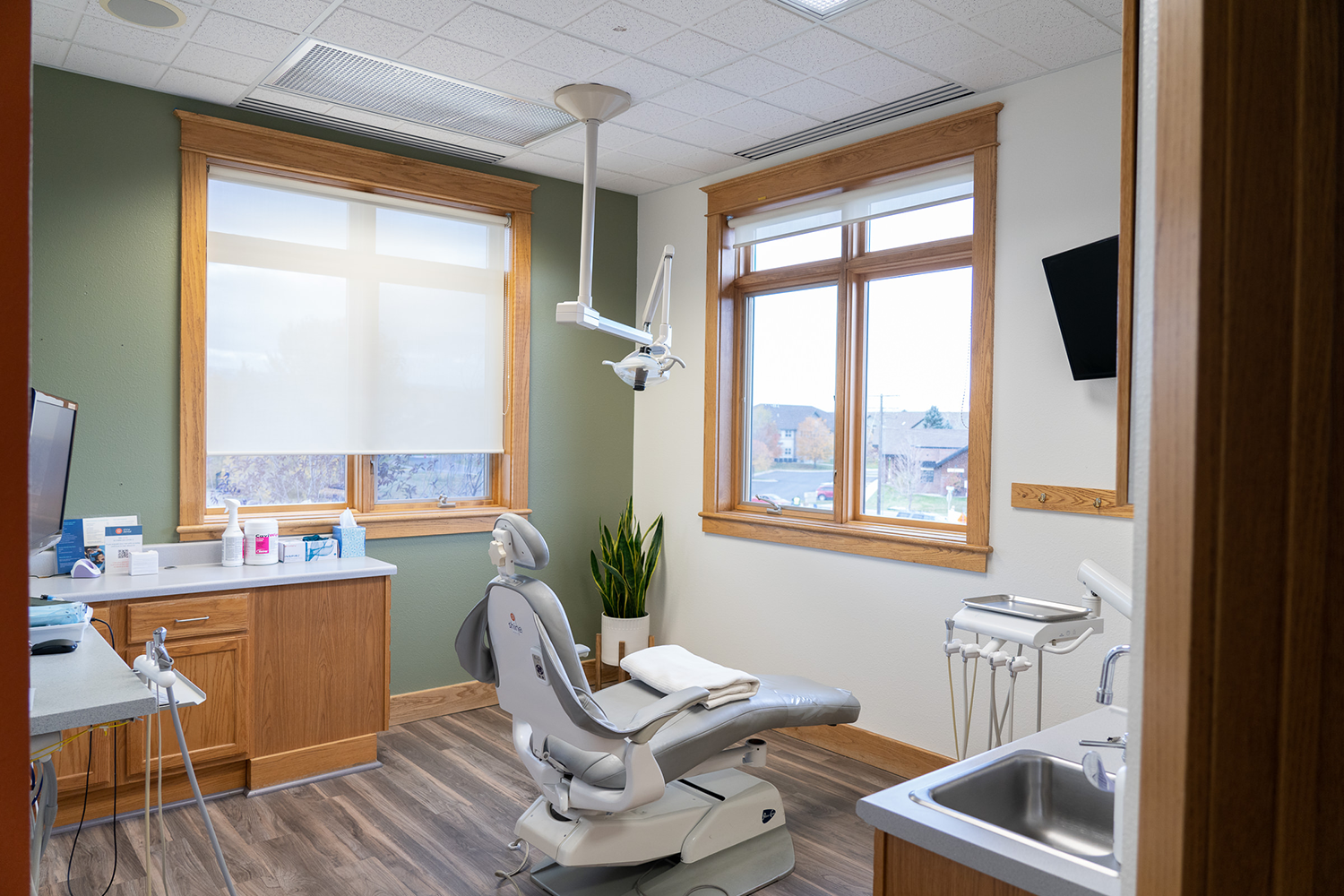 A dental office with a dental chair and a sink.