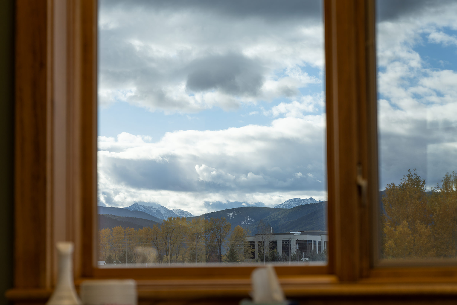 A window with a view of mountains and clouds