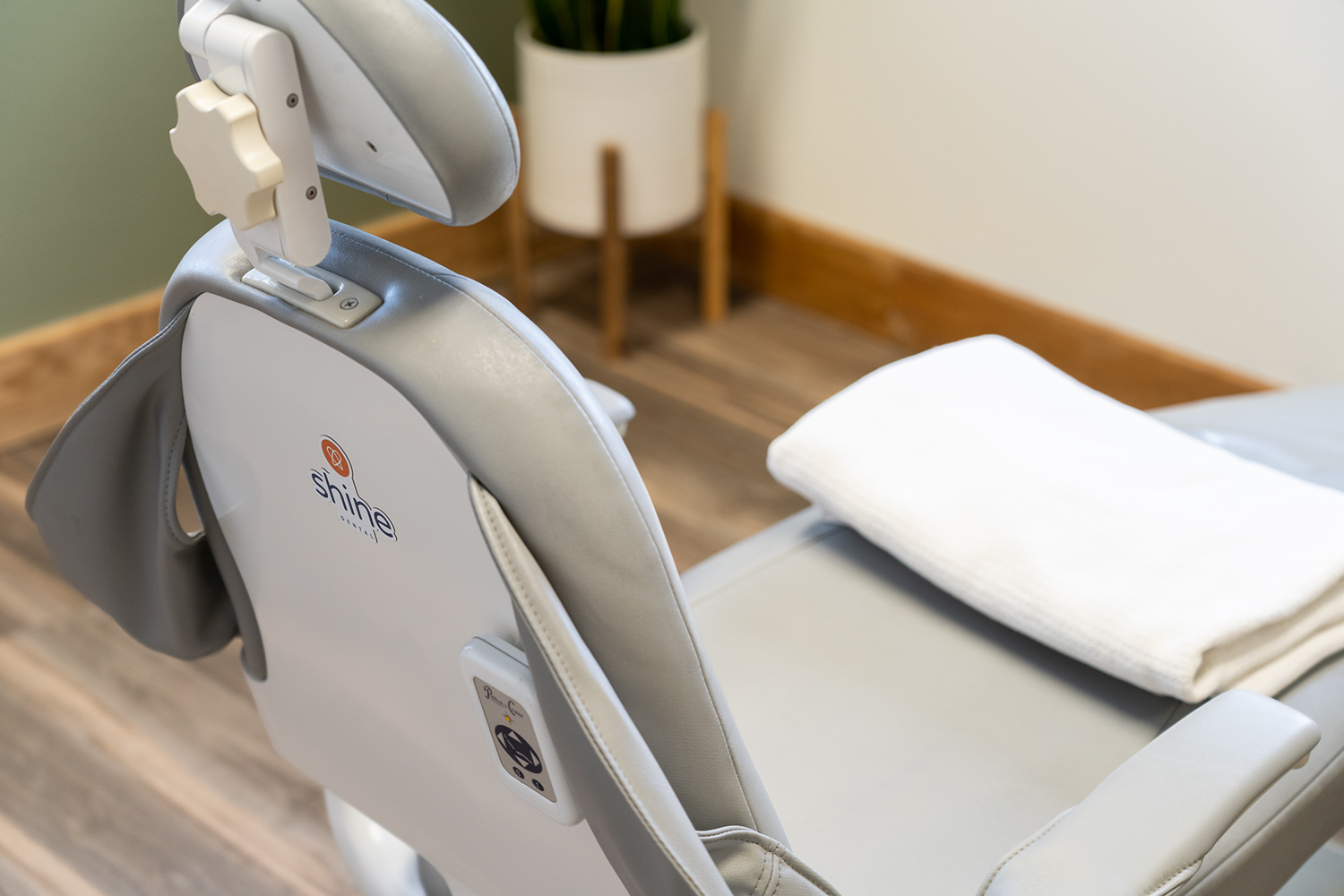 A dental chair with a blanket on it in a room.