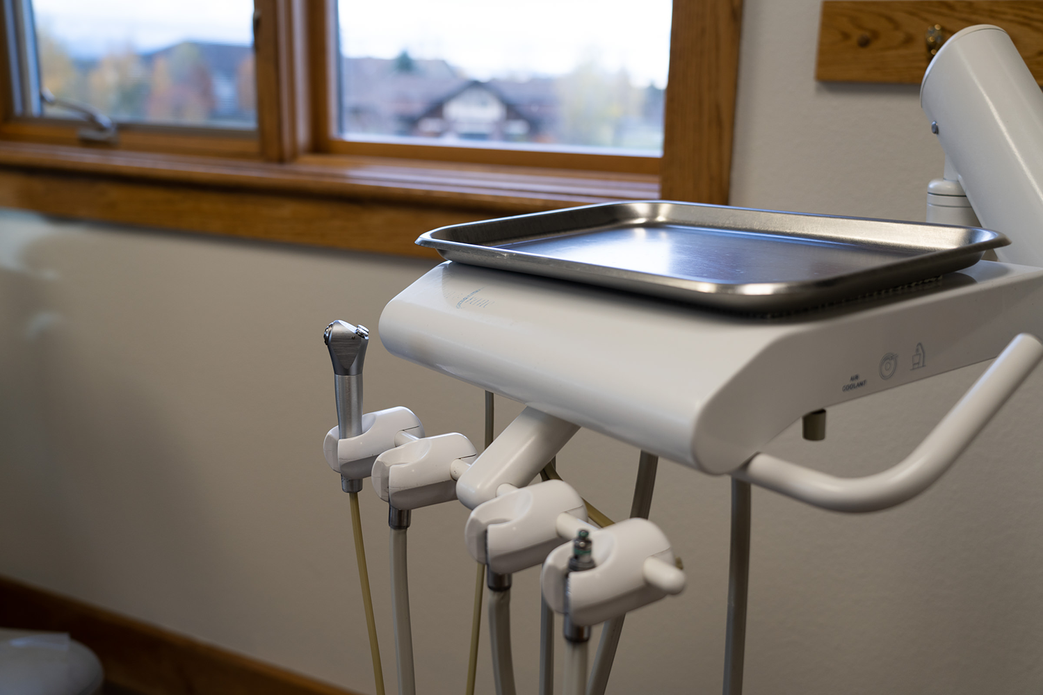 A dental machine with a tray on top of it in front of a window.