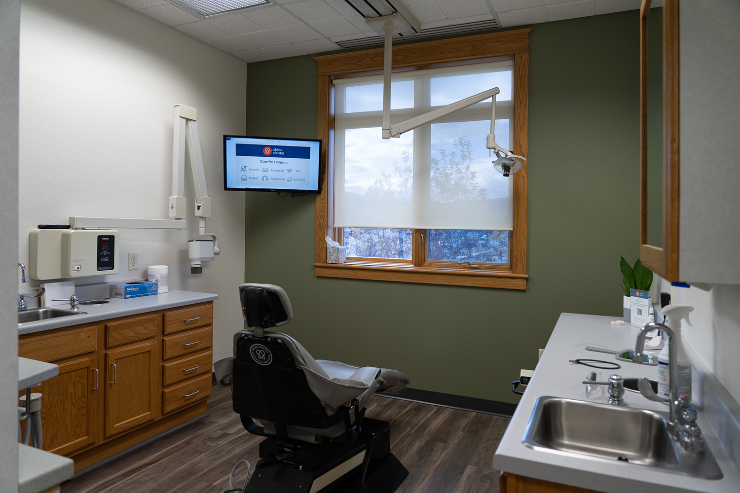 A dental office with a dental chair and a sink.
