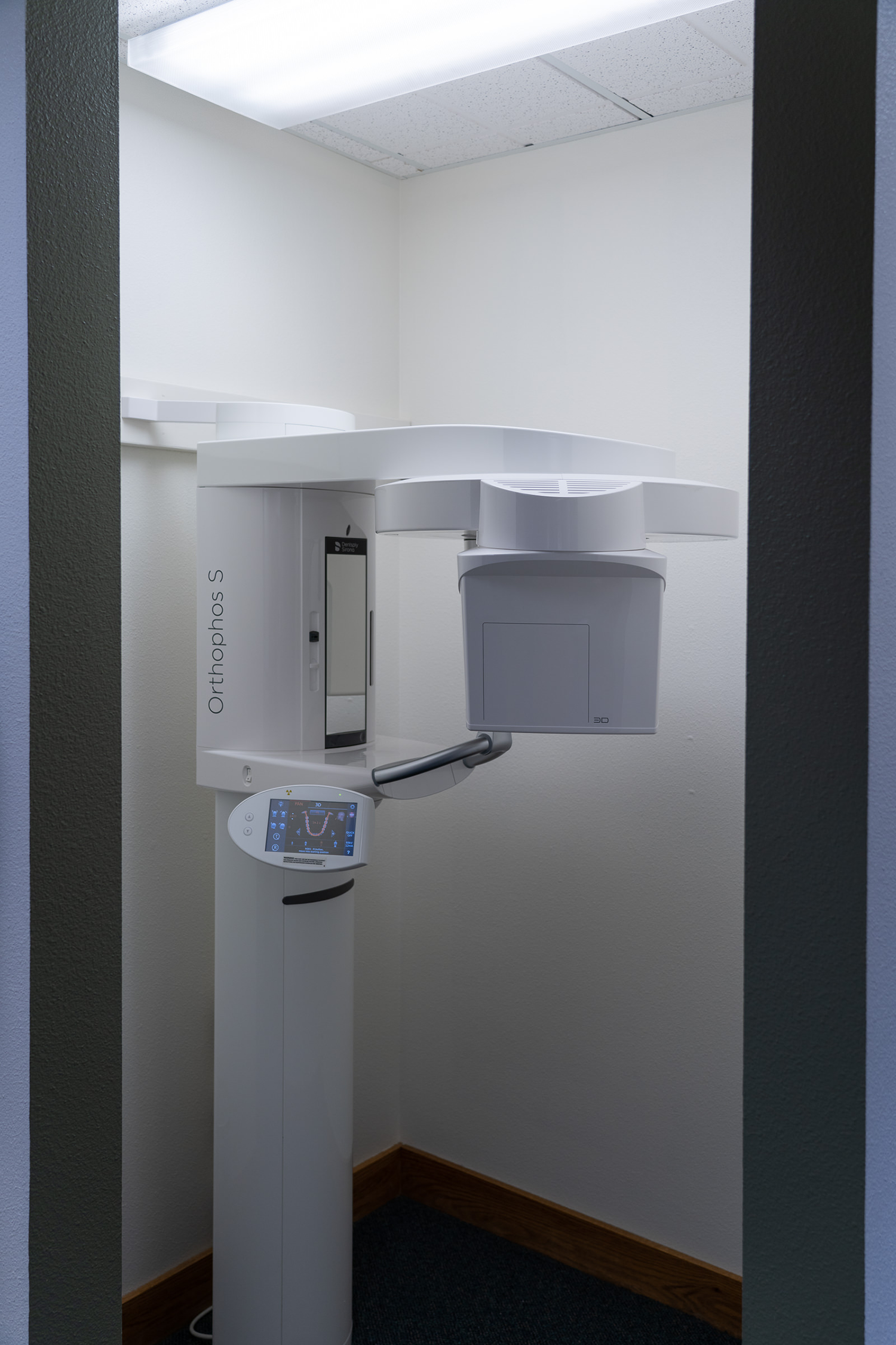 A dental x-ray machine is sitting in a small room.