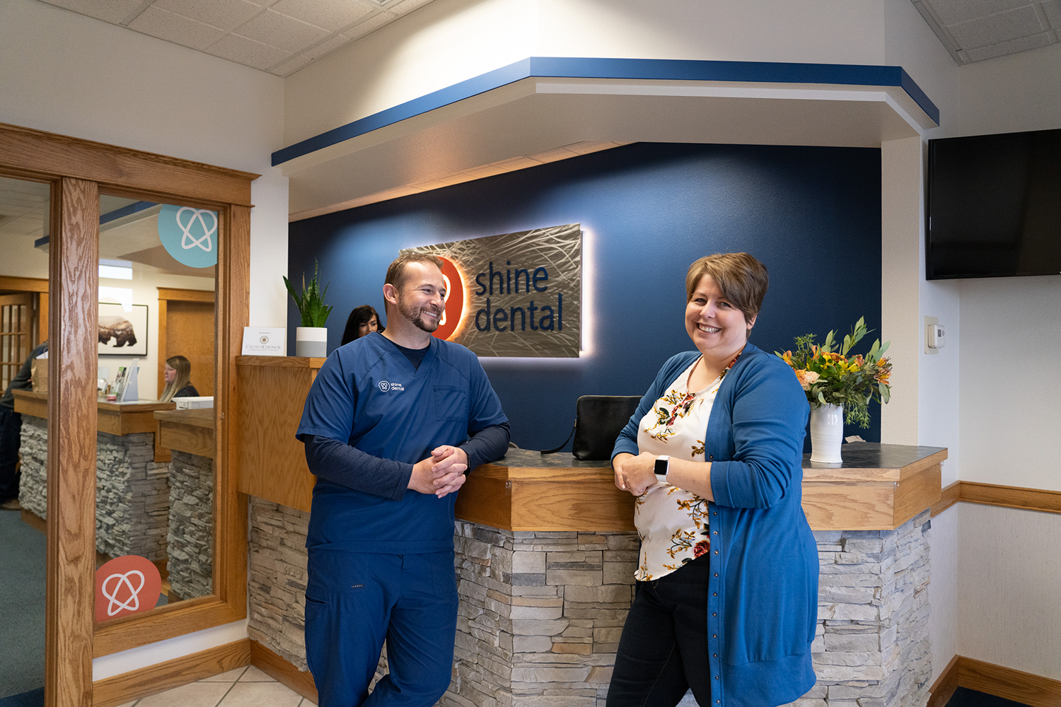 Dr. Justesen and a patient are standing next to each other in a dental office.