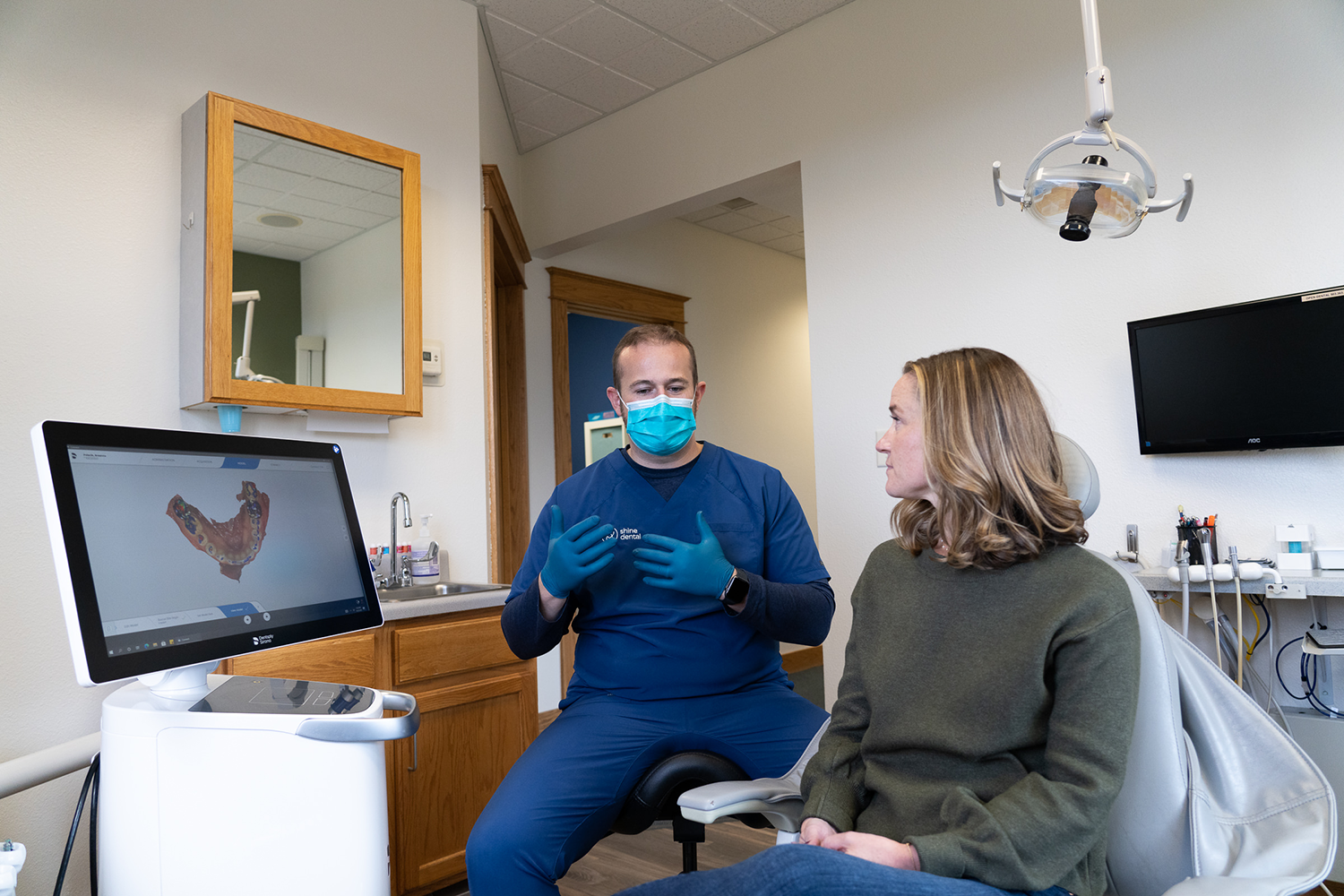Dr. J is talking to a patient in a dental office.