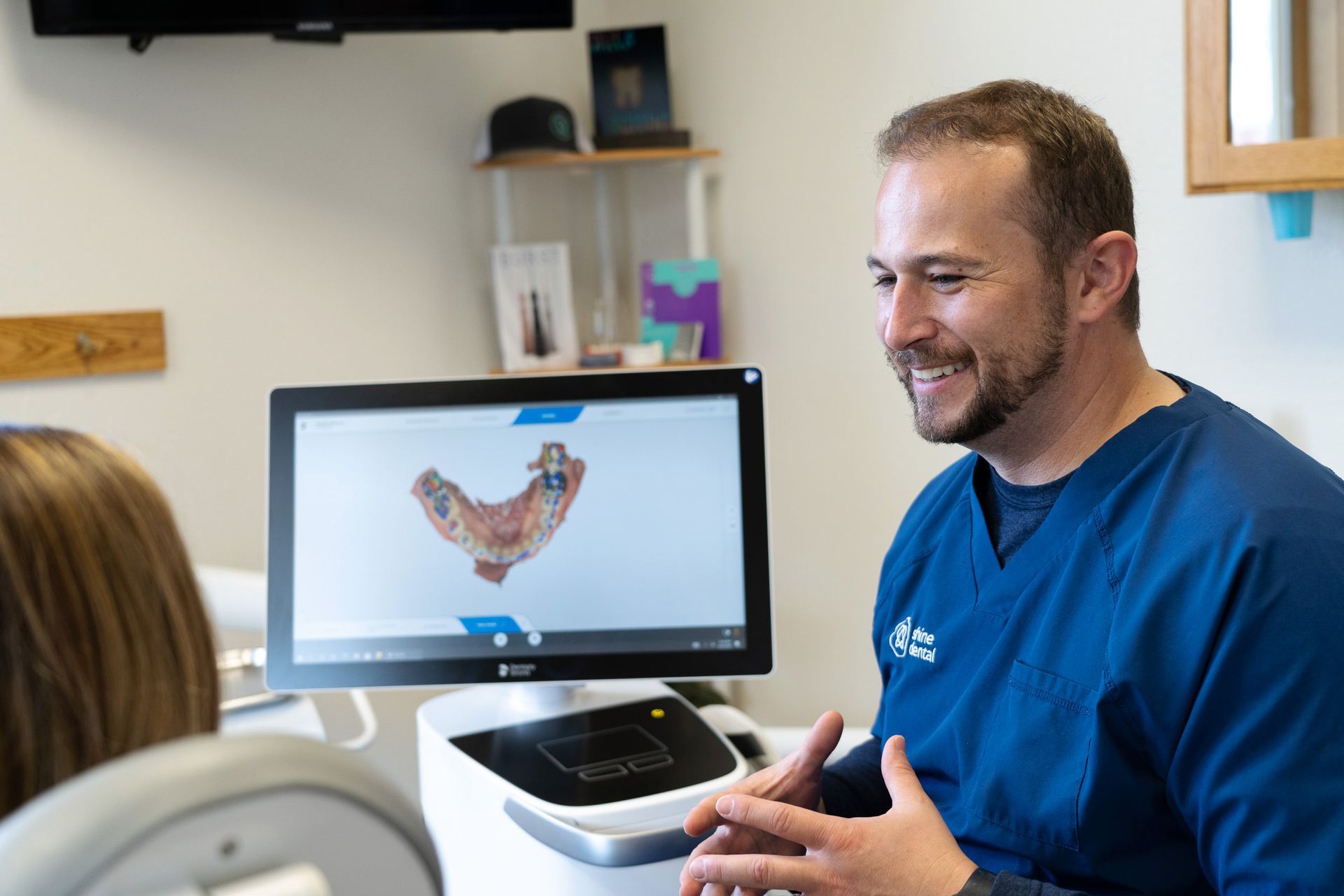 Dr. Justensen talking with a patient reviewing dental scans