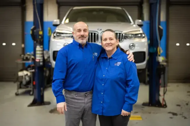 Owners in garage in front of BMW car in garage | Bavarian Motor Cars