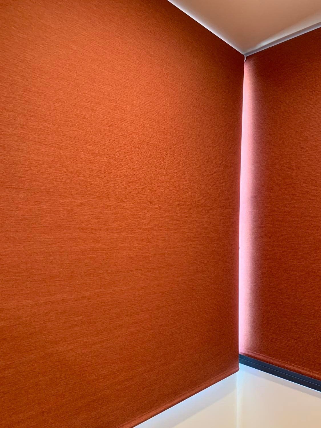 Closed Orange Roller Blind In Front Of Window — Blinds, Curtains And Shutters In Alice Springs, NT