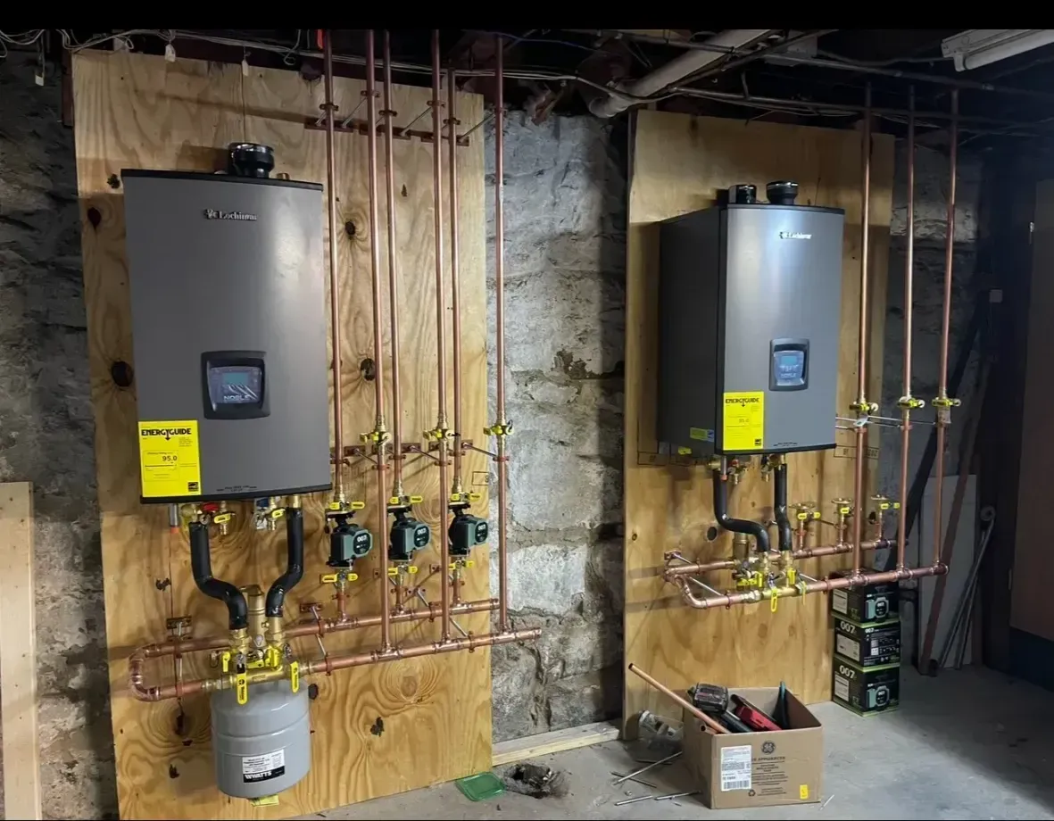 Two men are working on a water heater in a basement.