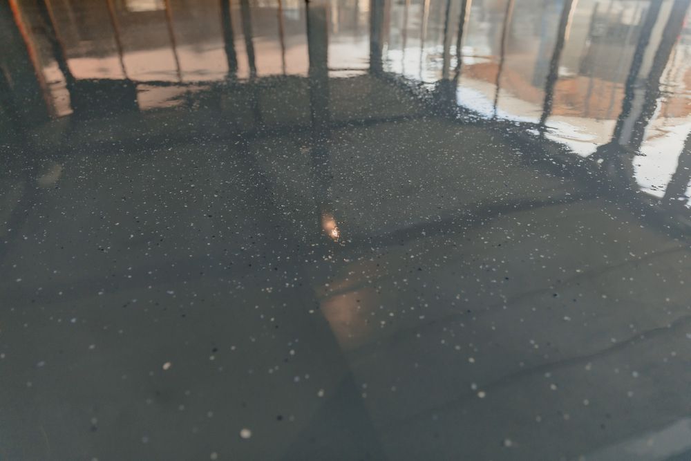 Woman in straw hat smiles, holding wine glass near a lake.