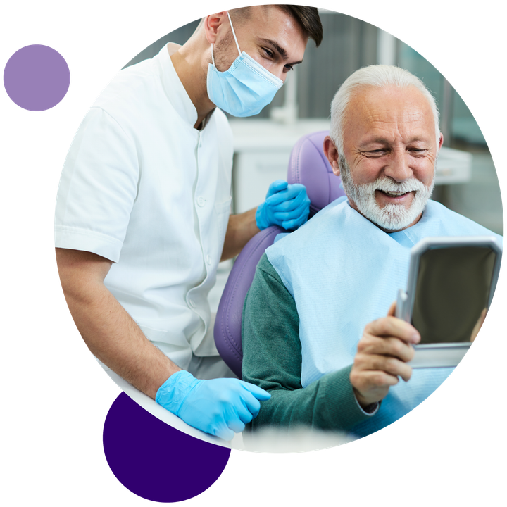 A dentist is looking at a patient's teeth in a mirror