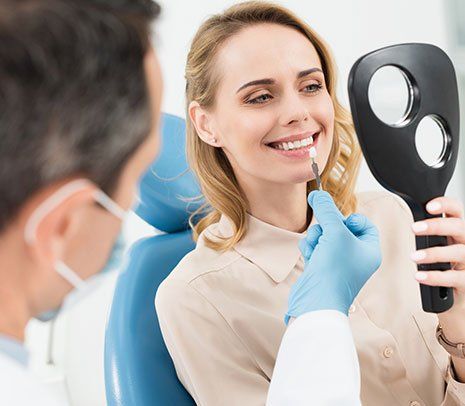Dental Implants — Patient Checking Tooth Implant in Brownsburg, IN