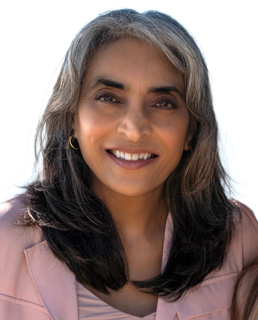 A woman in a pink jacket is smiling for the camera
