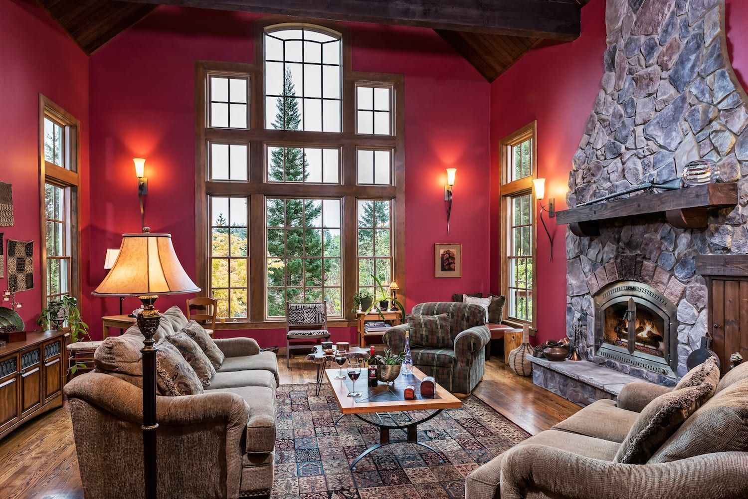 A living room with red walls and a fireplace