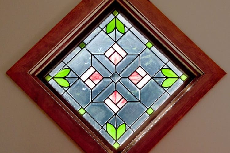 A stained glass window in a wooden frame