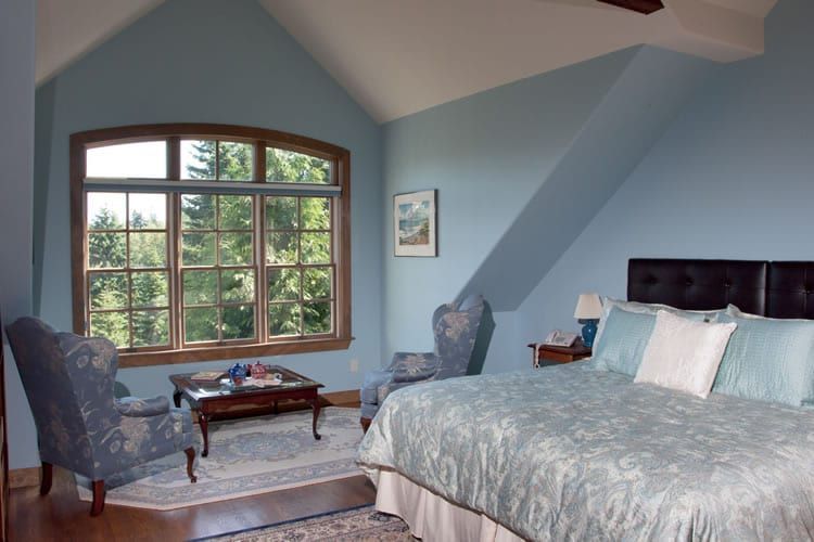 A bedroom with blue walls and a king size bed