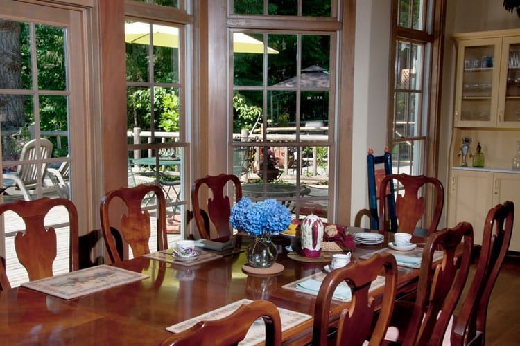 A dining room table with a vase of flowers on it