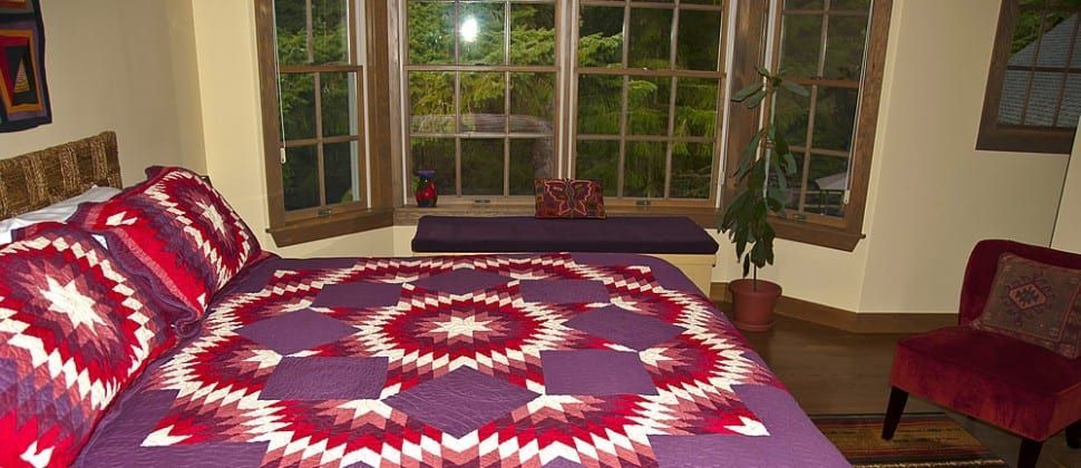 A bed with a purple and red blanket in a bedroom