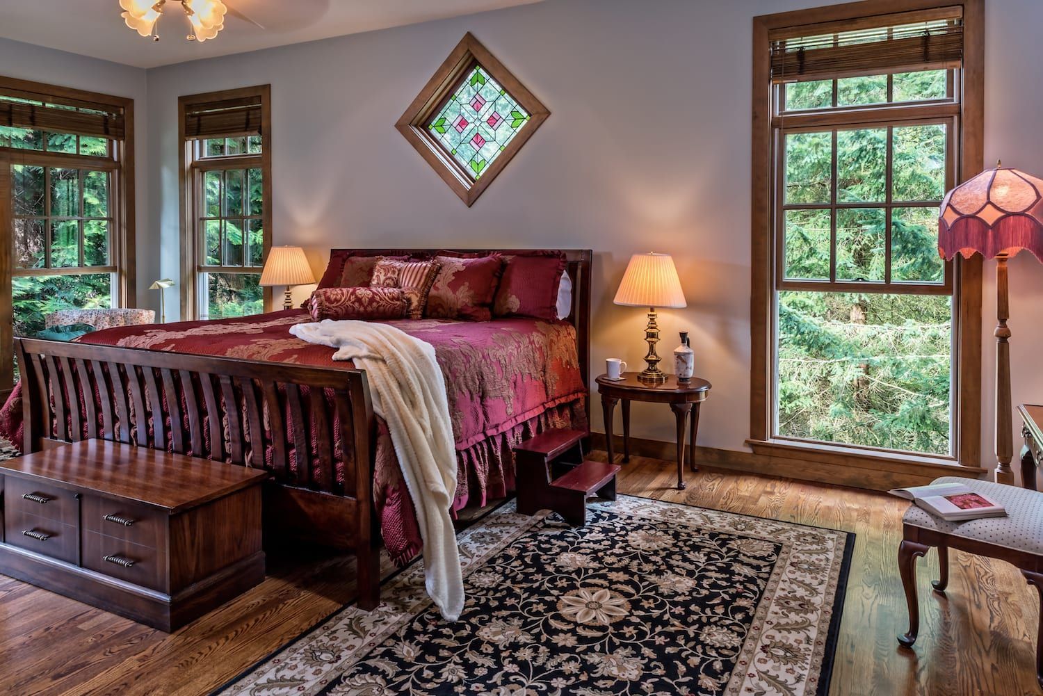 A bedroom with a bed , lamps , and a rug.