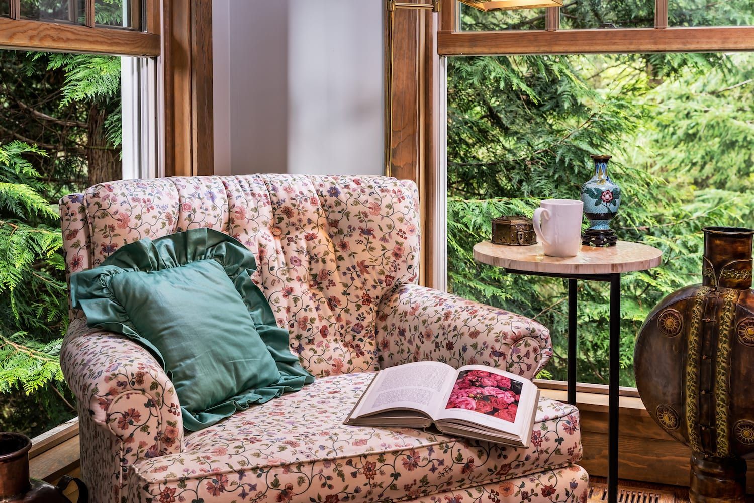 A chair with a book on it is sitting in front of a window.