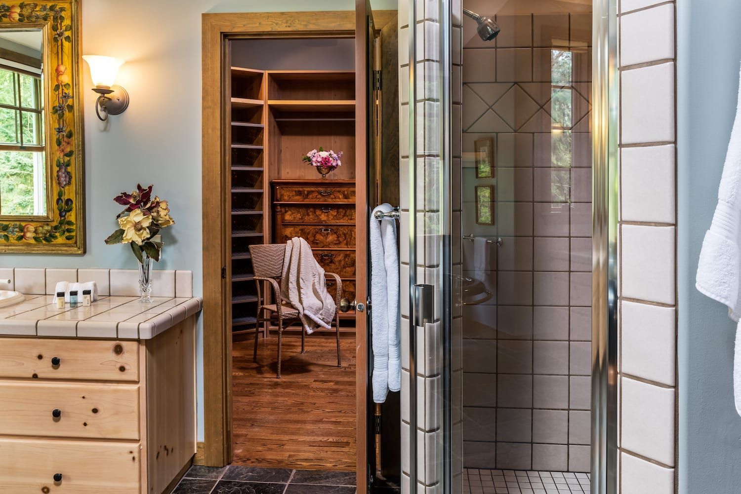 A bathroom with a walk in closet and a shower.