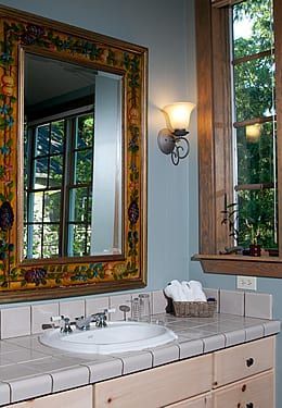 A bathroom with a sink , mirror and window