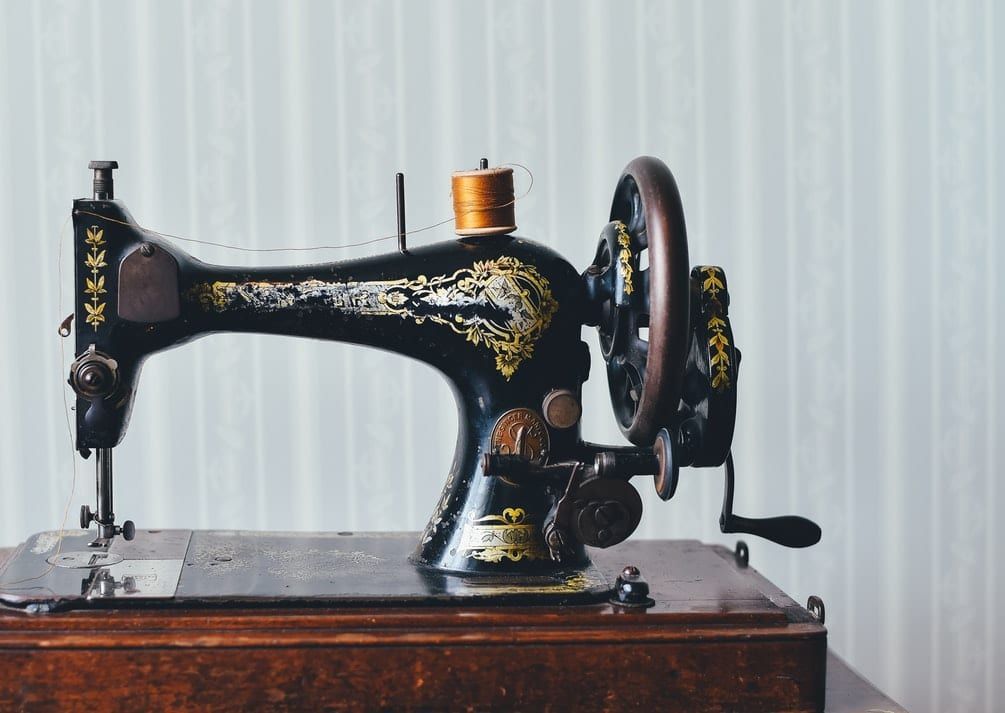 An old sewing machine is sitting on a wooden table.