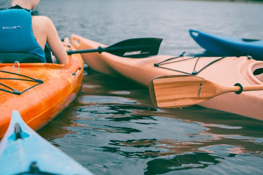 A group of kayaks are floating on top of a body of water.
