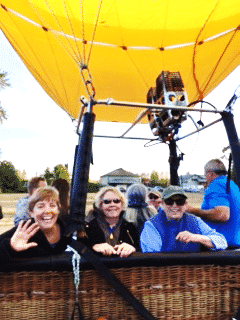 A group of people are sitting in a hot air balloon.