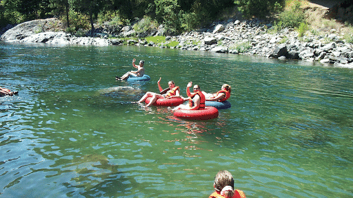 A group of people are floating down a river on inner tubes.