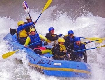 A group of people in a raft that says ace on it