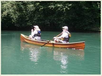 Two people are in a canoe on a river.