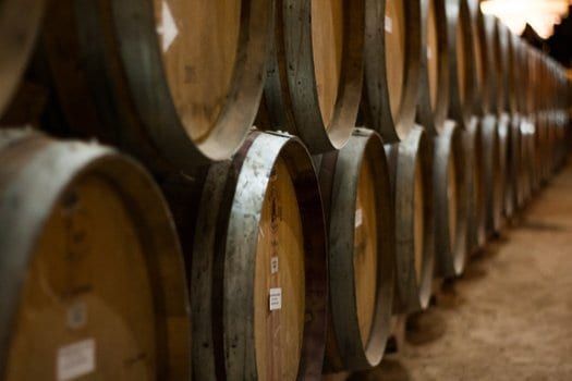 A row of wooden wine barrels in a wine cellar.