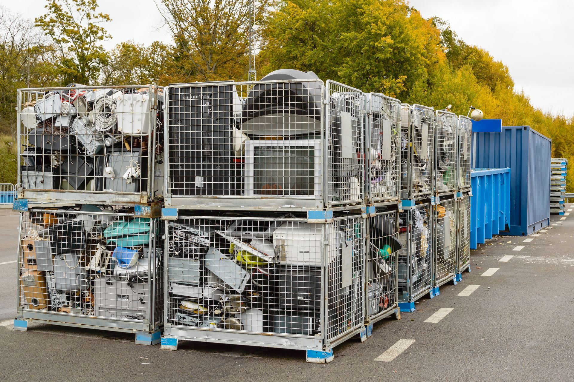 A bunch of crates filled with electronic waste are sitting on the side of the road.