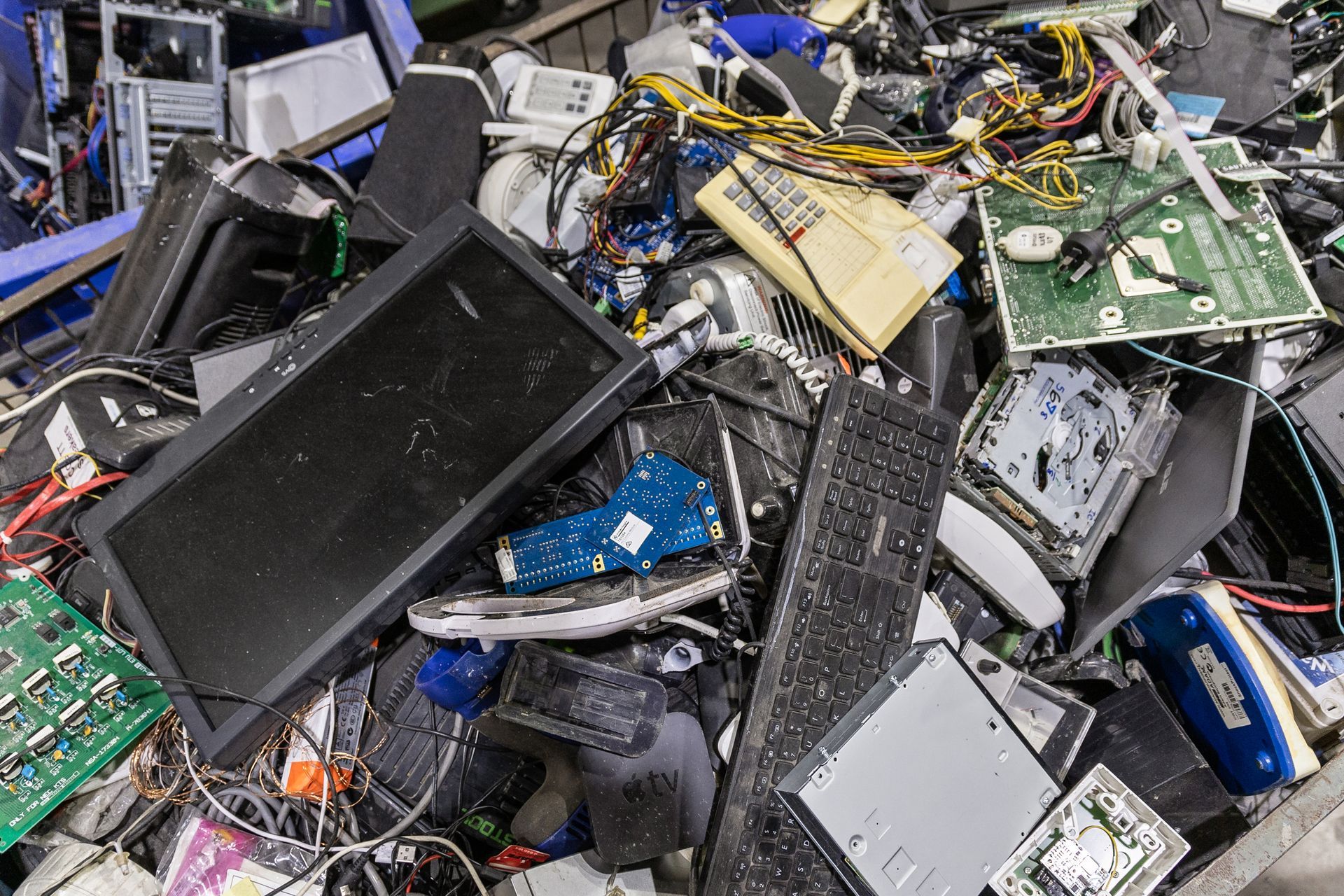 A pile of broken electronic components including a keyboard
