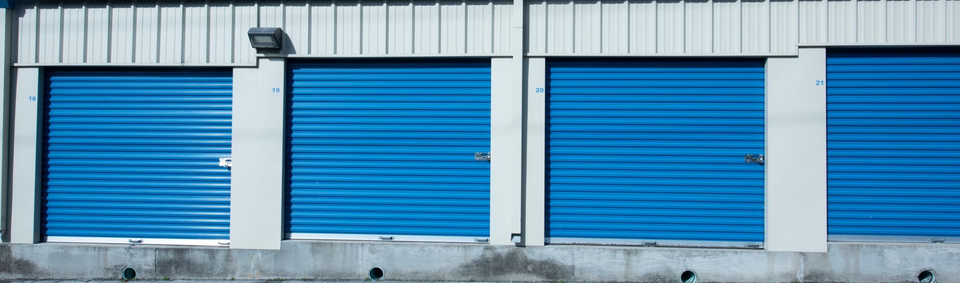 A row of blue garage doors on the side of a building.