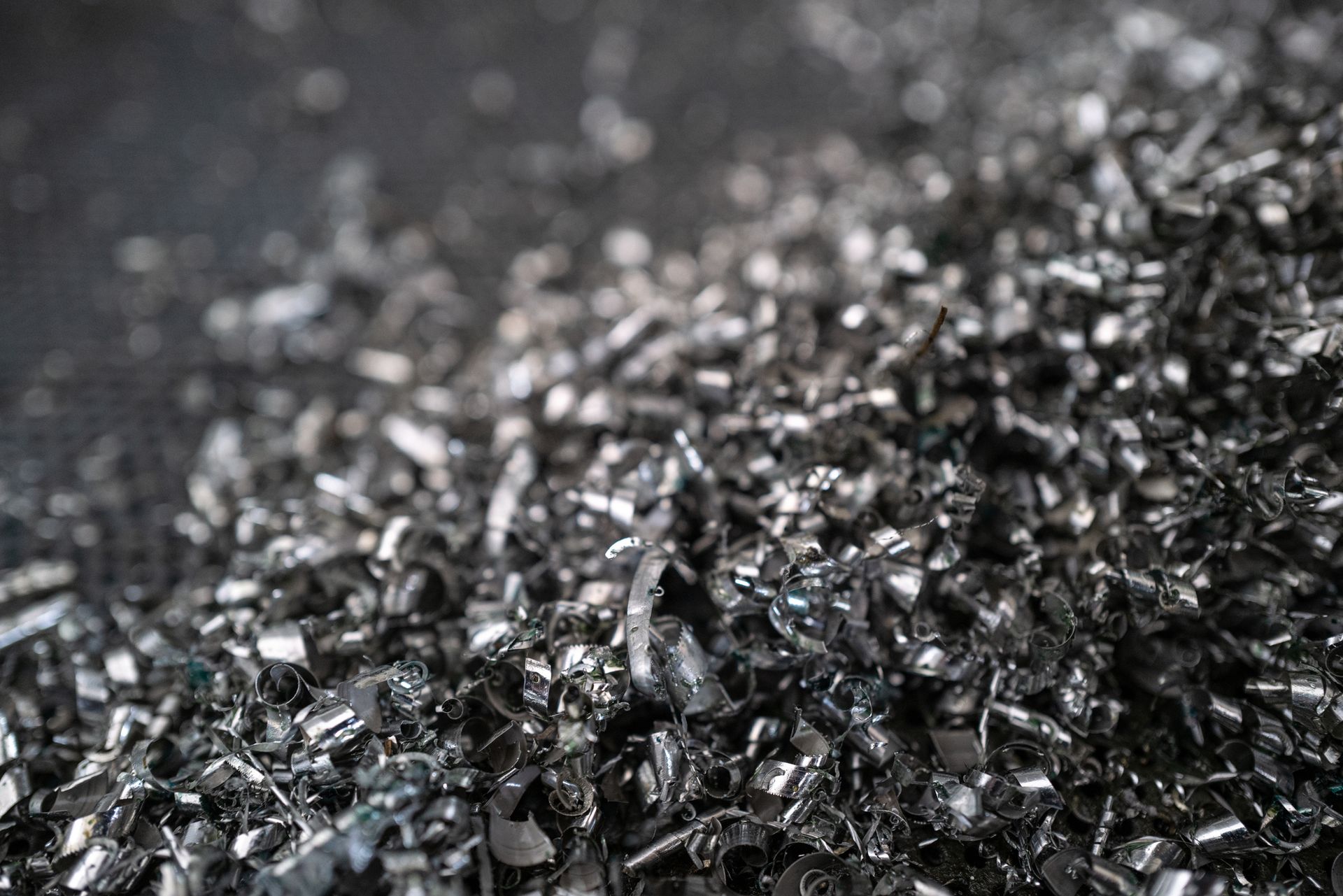 A pile of black metal shavings on a black surface.