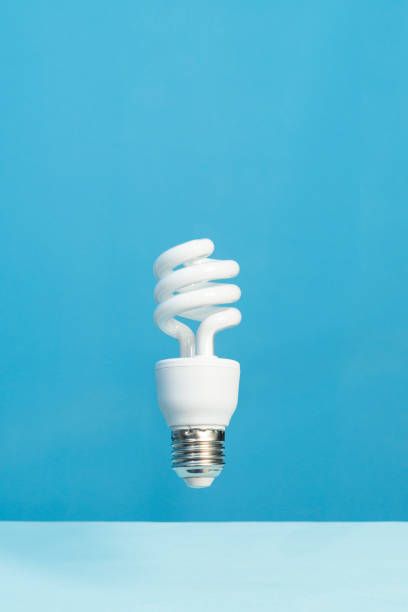 A white light bulb is floating in the air on a blue background.