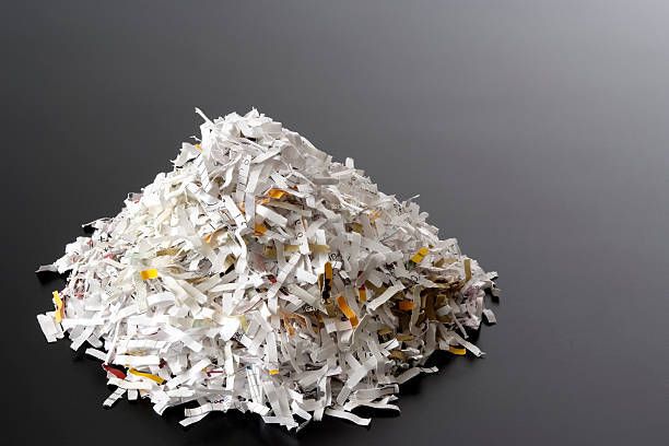 A pile of shredded paper on a black surface.
