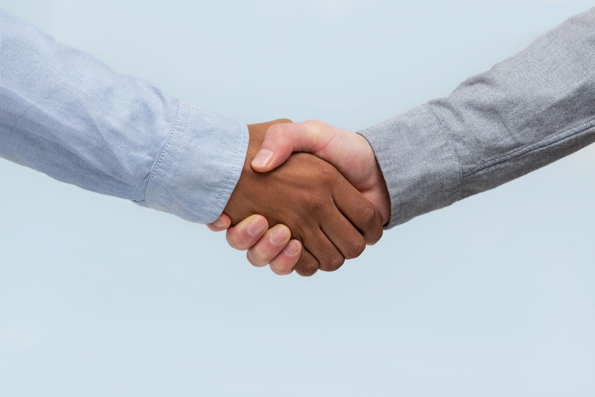 Two people are shaking hands on a blue background.