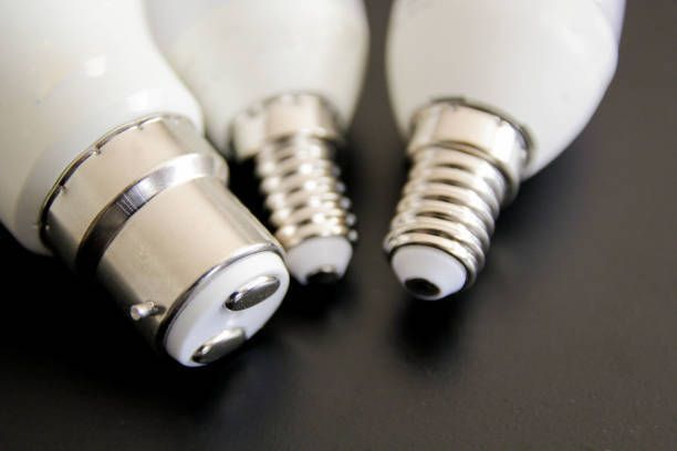 Three different types of light bulbs are sitting on a table.