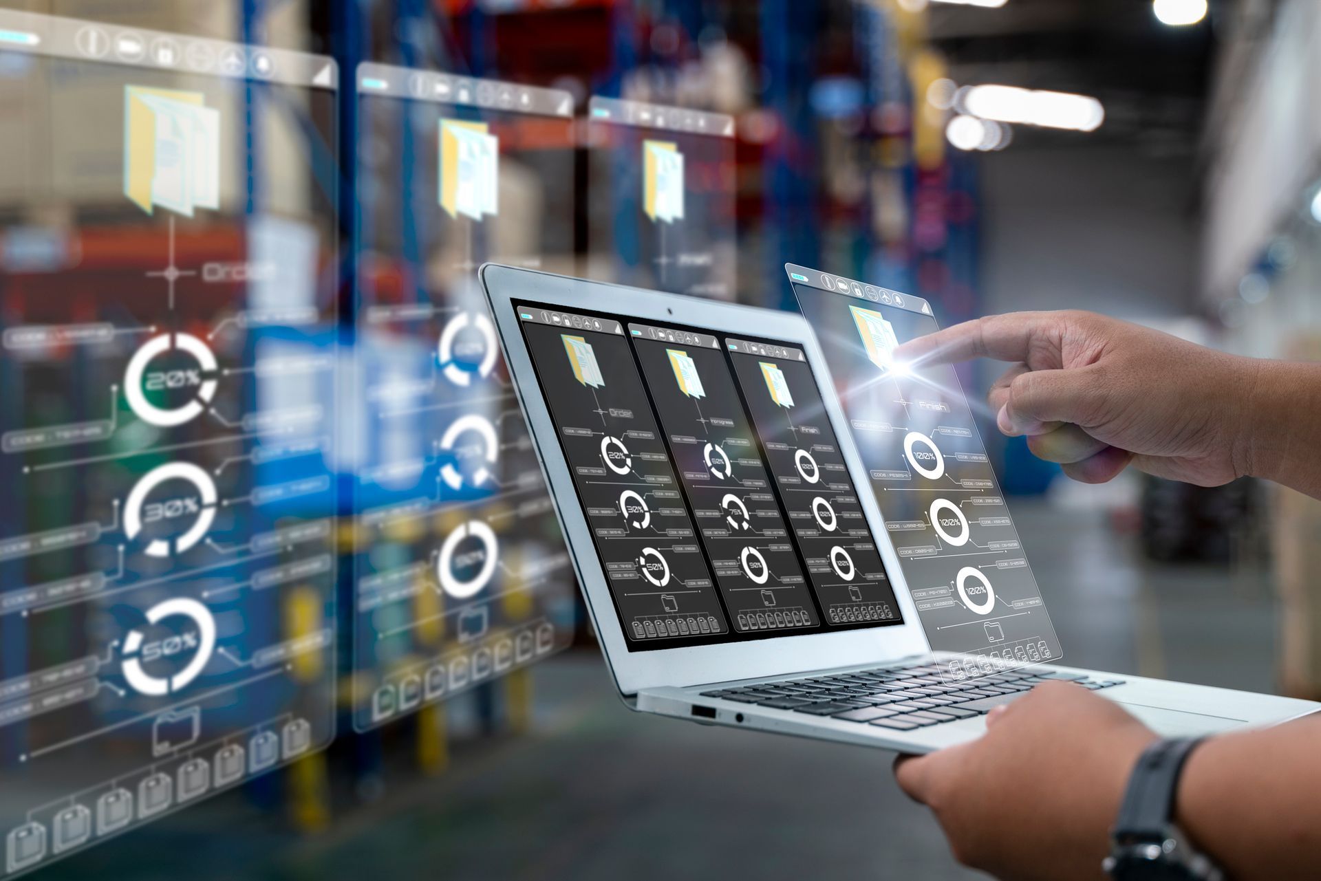 A person is using a laptop computer in a warehouse.