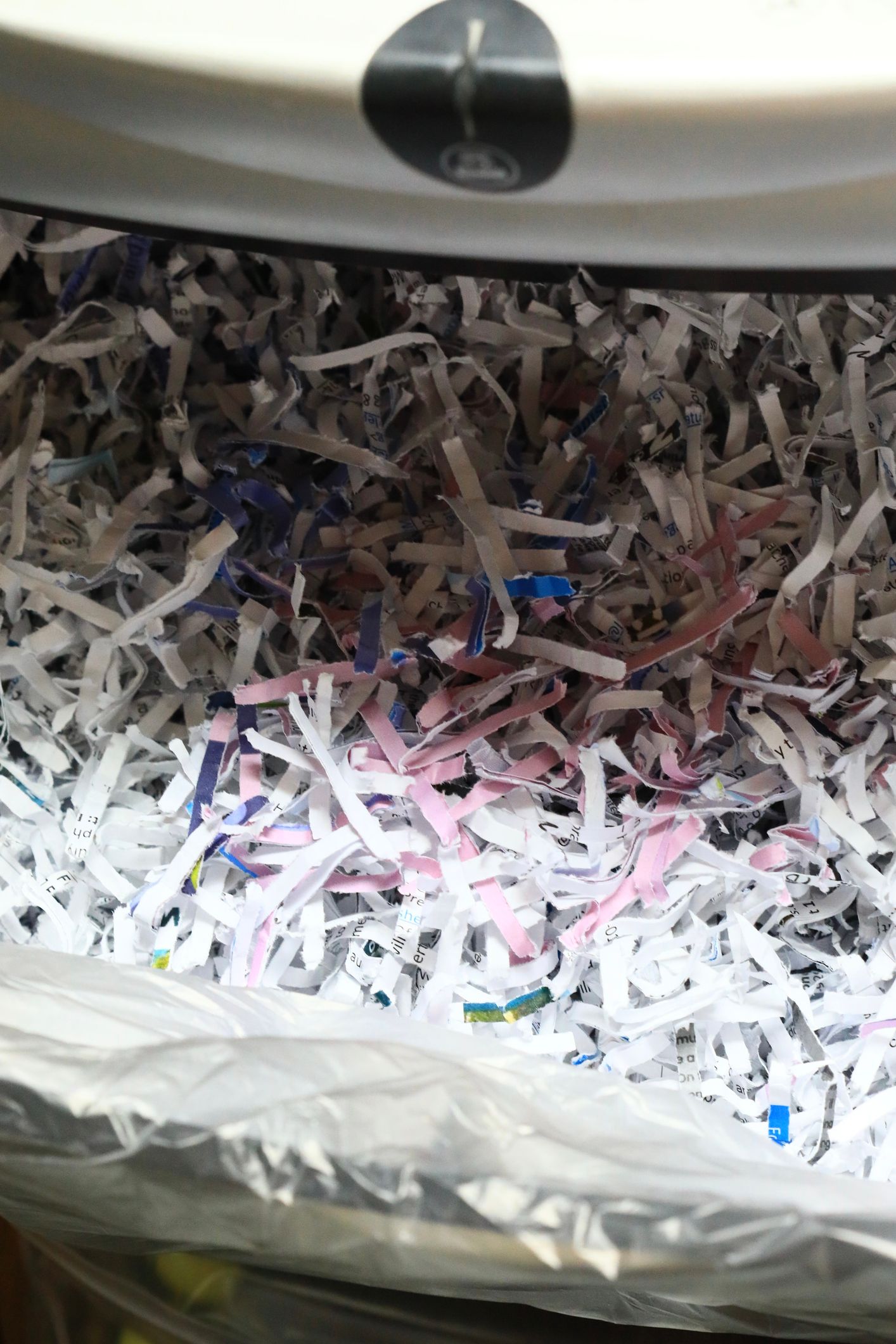 A pile of shredded paper is sitting in a trash can.