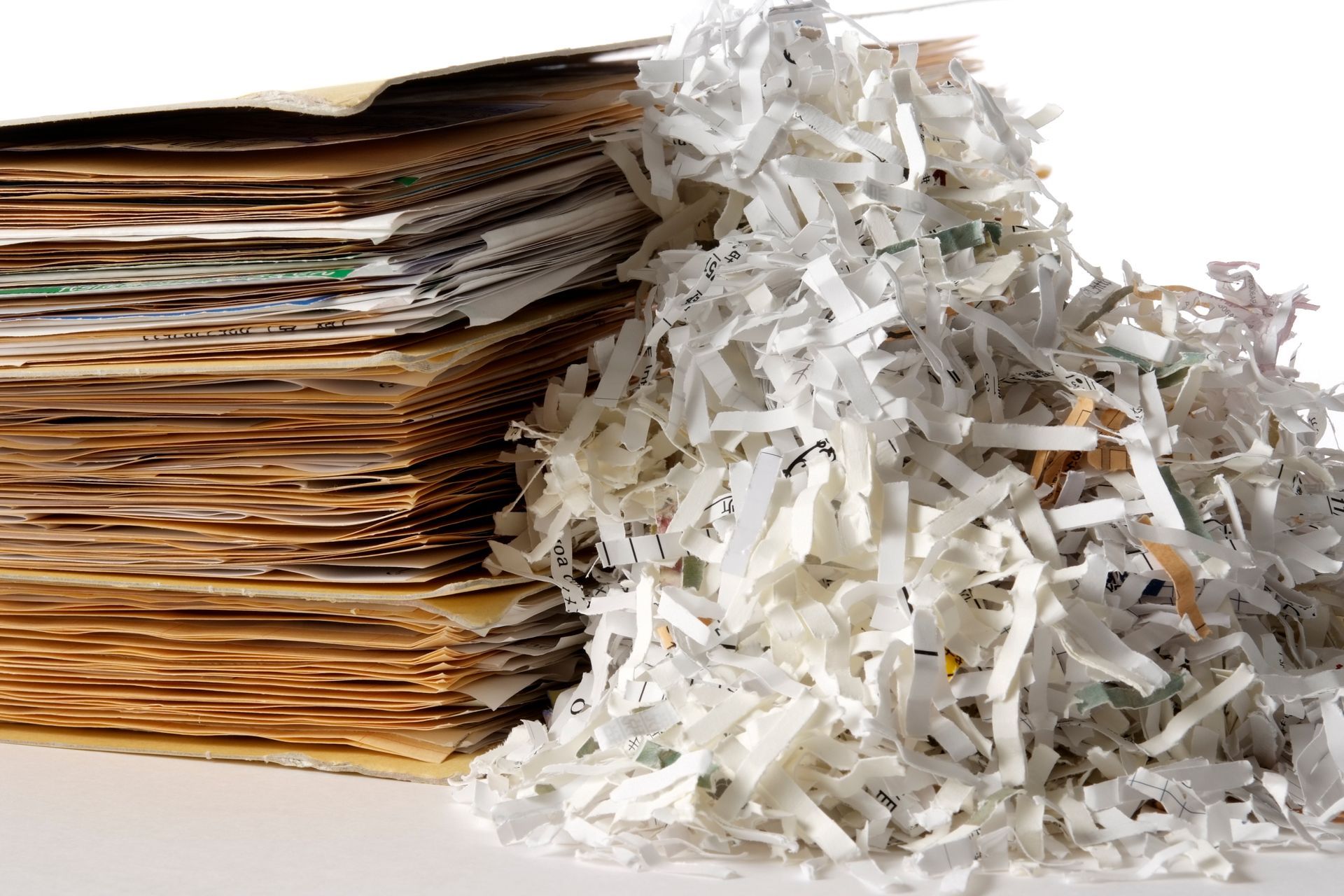 A pile of shredded paper next to a pile of cardboard