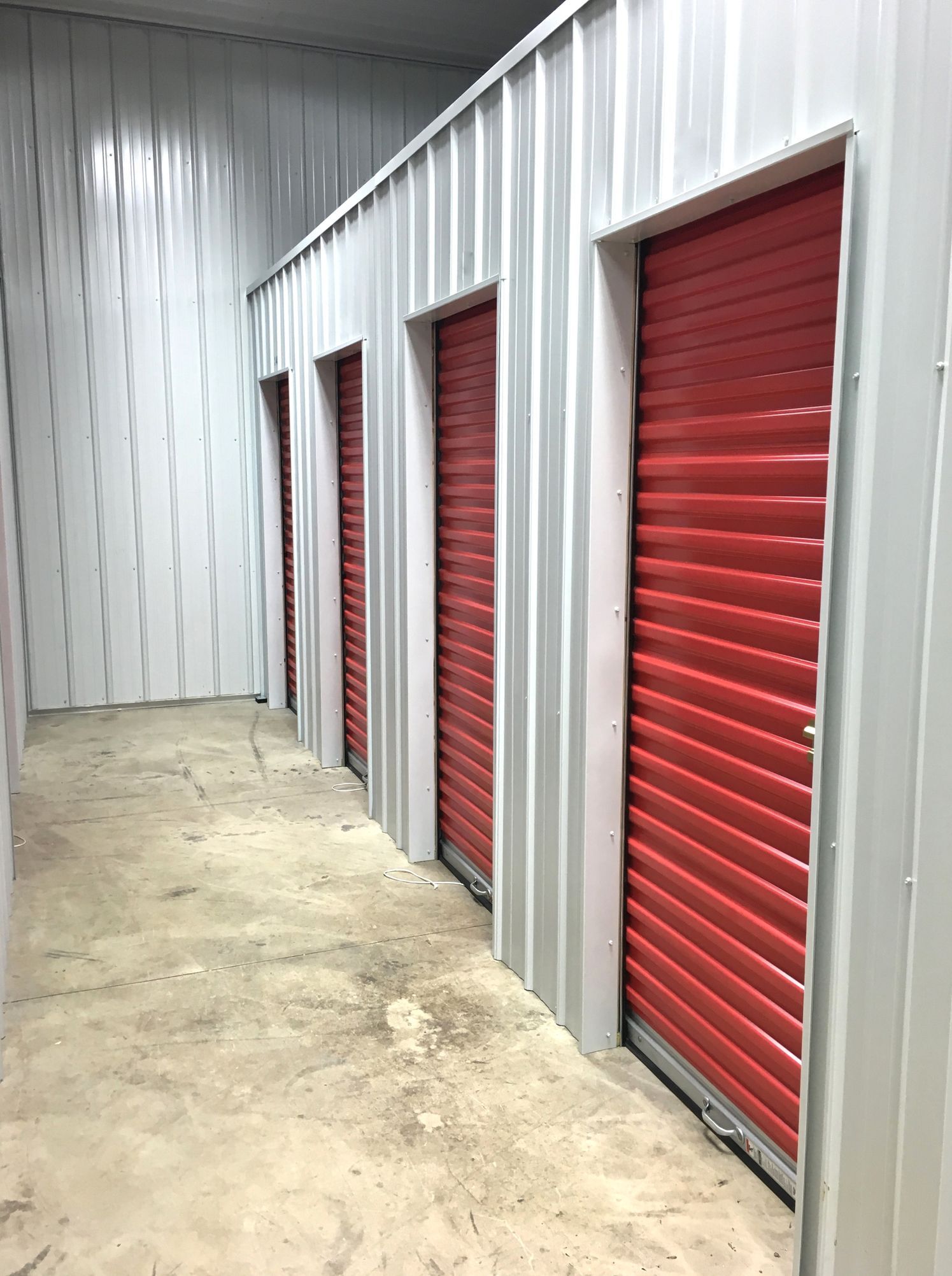 A row of storage units with red doors and white walls.