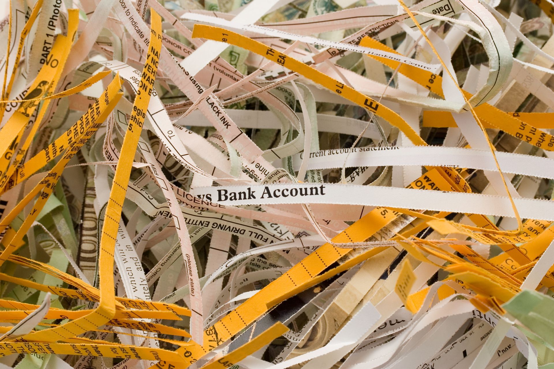 A pile of shredded paper that says bank account on it