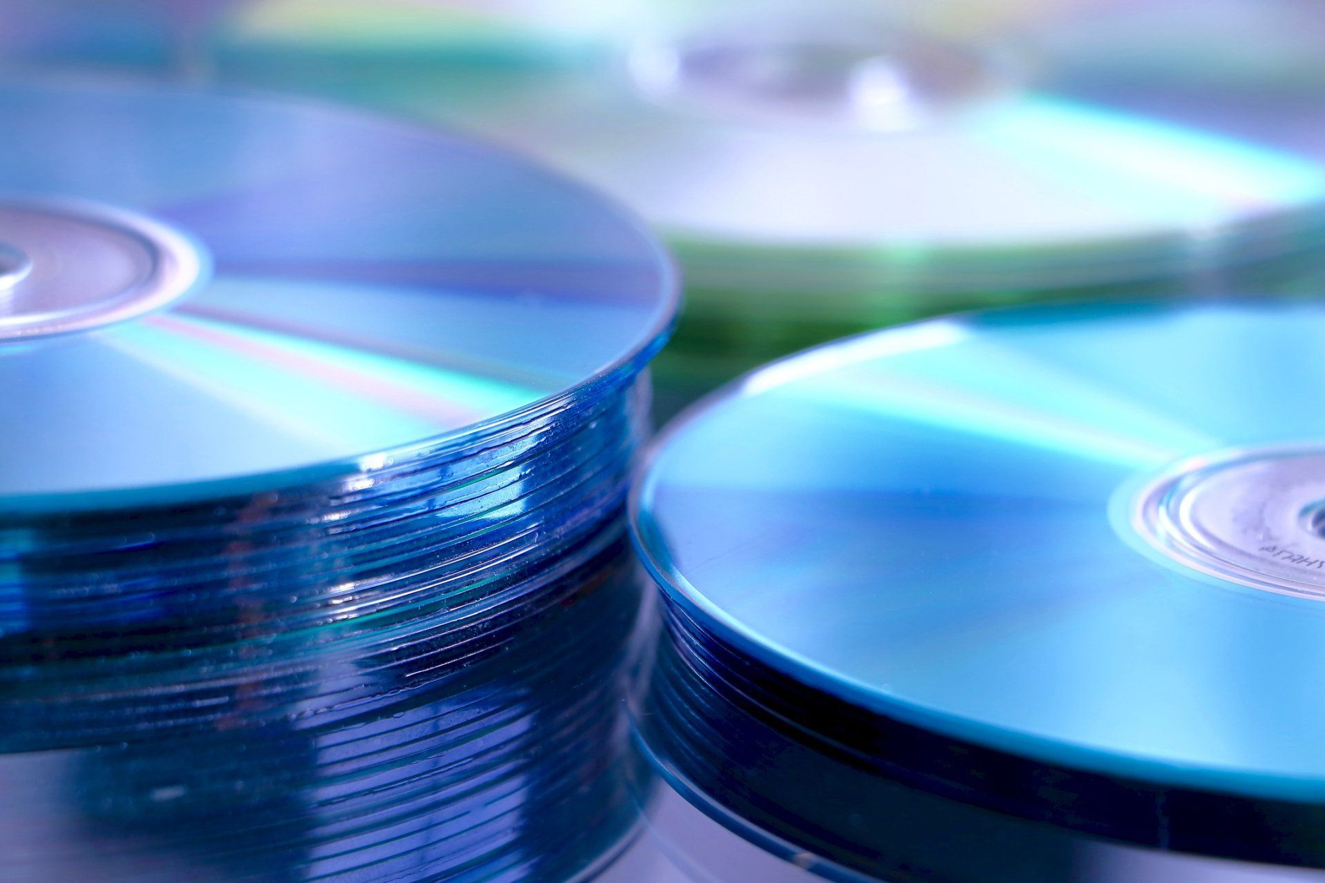 Three stacks of blue cds are sitting on top of each other on a table.