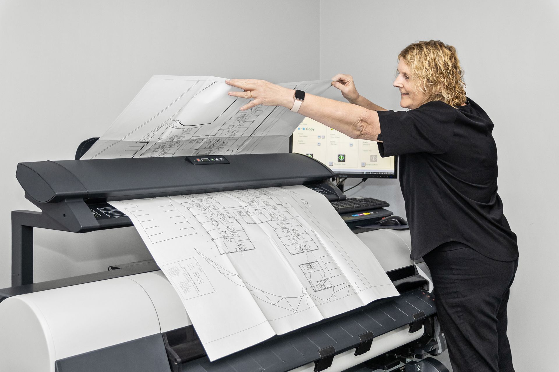 A man is using a scanner to scan a document.