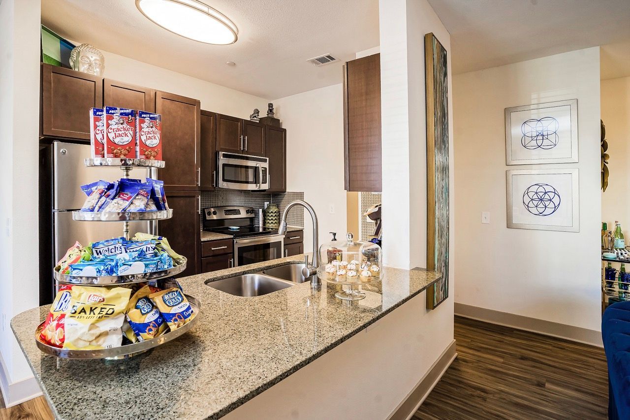 Open-concept kitchen with granite island, dark wood cabinets, and stainless-steel appliances.